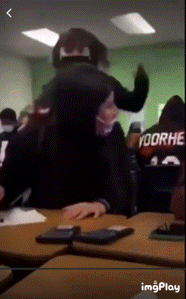 a group of people in a classroom with a shirt that says voorhe