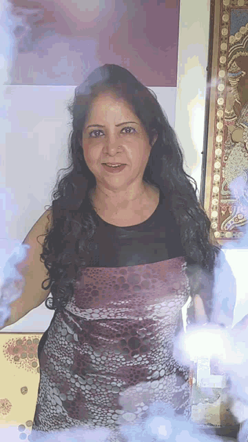 a woman in a purple and black dress is smiling