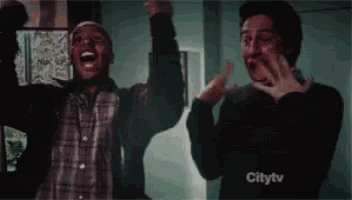a couple of men are standing next to each other with their arms in the air and a citytv logo in the corner