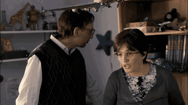 a man and a woman are standing next to each other in front of a shelf with a star on it