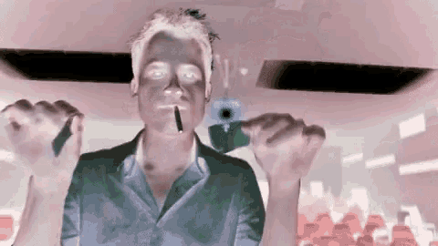 a man smoking a cigarette and holding a cell phone in his hands