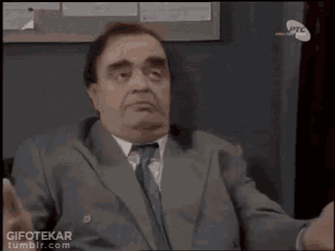 a man in a suit and tie is looking up and the word om is above him