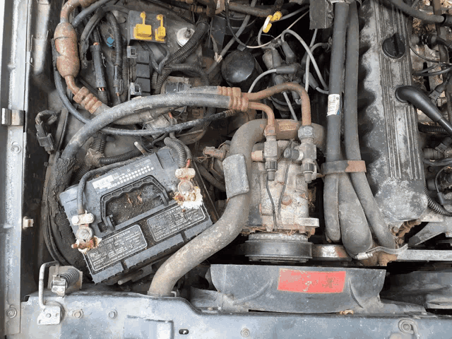 a car engine with a battery and a sticker that says ' warning ' on it