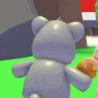 a gray teddy bear is standing on a green field next to a person holding an orange .