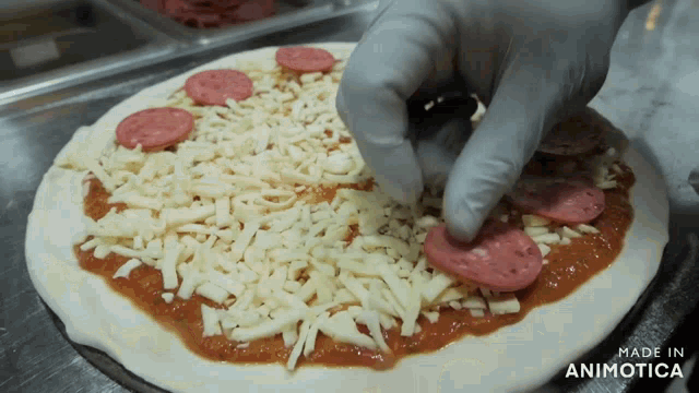 a pizza with cheese and pepperoni being made in animatica