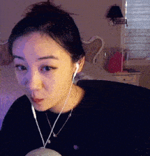 a woman wearing ear buds and a necklace