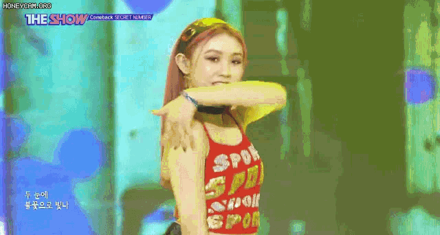 a woman in a red tank top is standing on a stage .