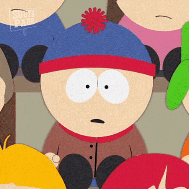 stanley from south park is sitting in a crowd of people with a surprised look on his face .