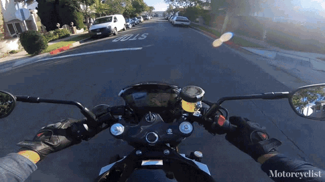 a person riding a motorcycle down a street with a stop sign on it