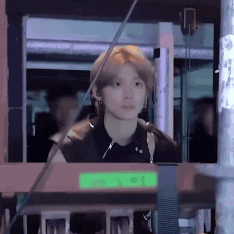 a man in a black shirt is standing in front of a green sign that says ' n ' on it