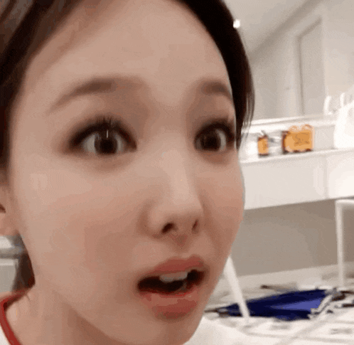 a close up of a woman making a surprised face with her mouth open .