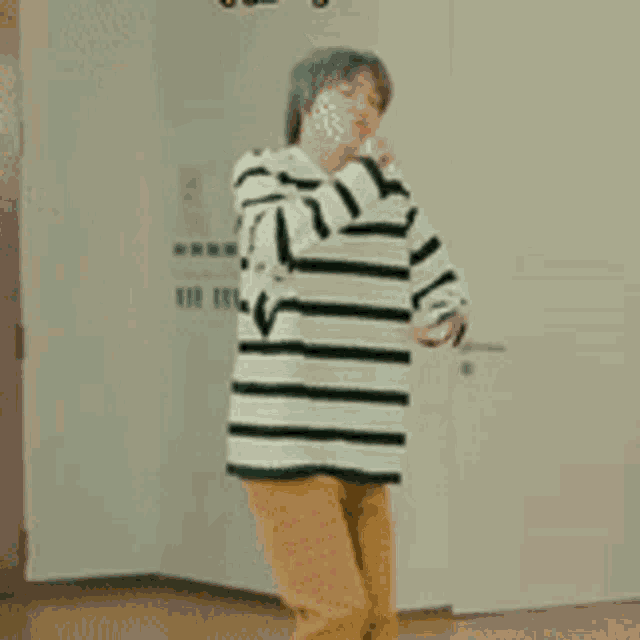 a man wearing a striped shirt and yellow pants is standing in a room