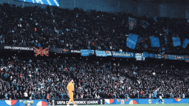 the uefa conference league is advertised on the sidelines of a soccer game