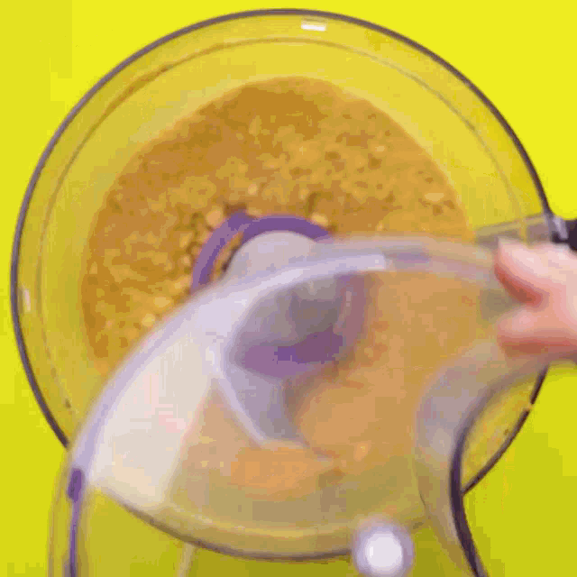 a person is pouring sliced bananas into a food processor with the word banana on the bottom