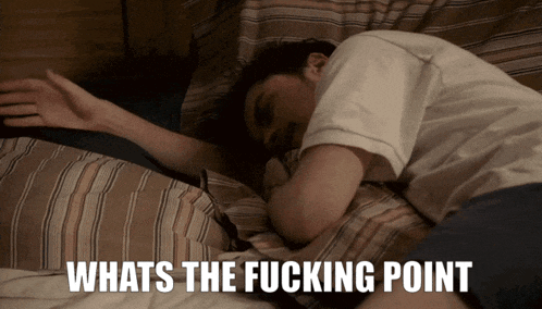 a man laying on a bed with the words " whats the fucking point " below him