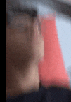 a blurry picture of a man 's face with a red pillow behind him .