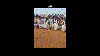 a group of people are standing in a field with a flag in the background .