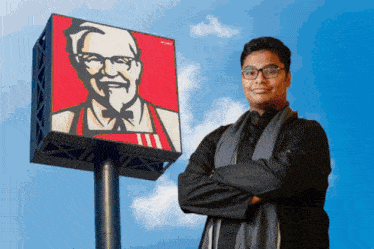 a man standing in front of a kfc sign