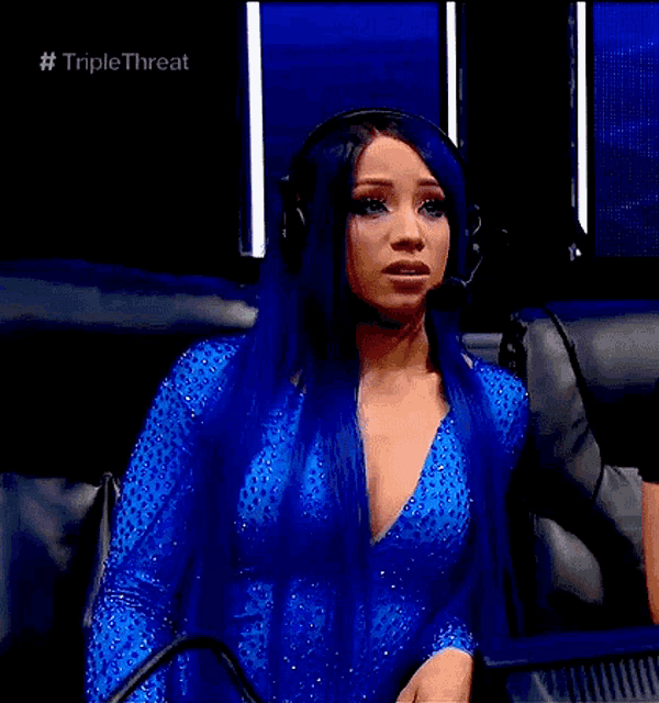 a woman with long blue hair is wearing headphones and a blue dress .