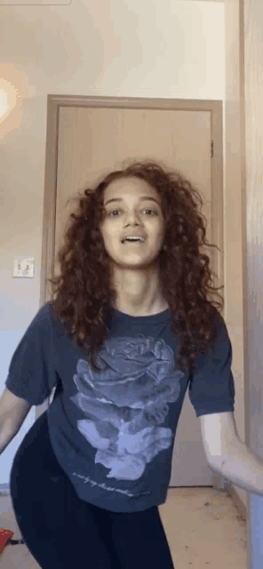 a woman with curly hair is wearing a t-shirt that says " i 'm sorry "