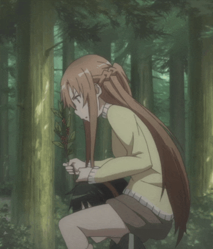 a girl in a yellow sweater is sitting in a forest