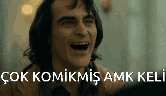 a man is laughing with the words " çok komikmis amk keli " written below him