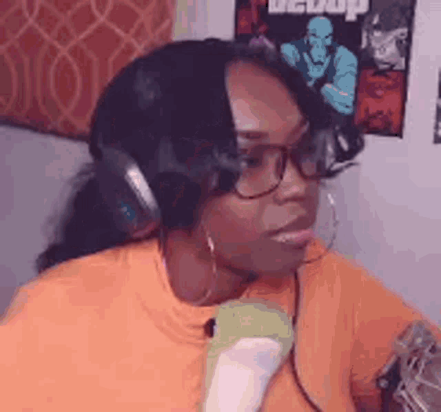 a woman wearing headphones and glasses is sitting on a couch in front of a microphone .