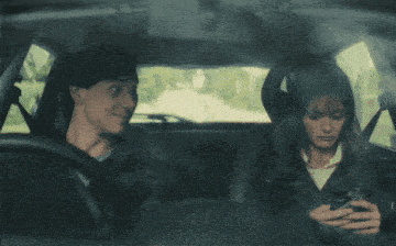 a man and a woman are sitting in a car and the man is smiling