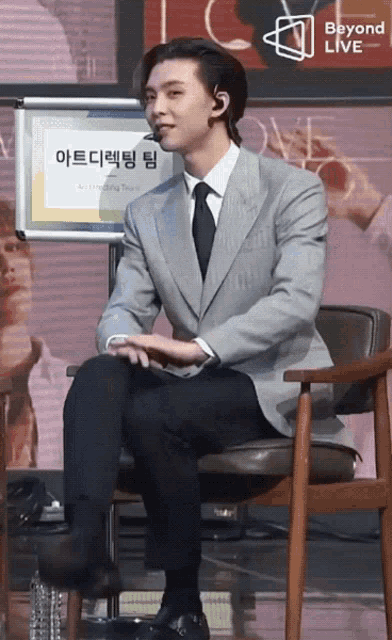 a man in a suit and tie is sitting in a chair