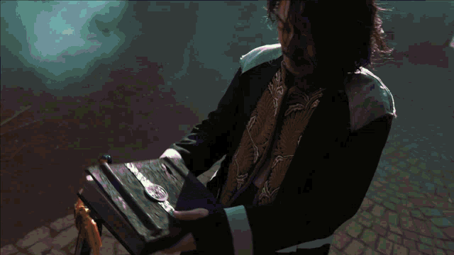 a man is reading a book with a sword on the ground