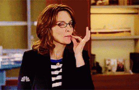 a woman wearing glasses and a striped shirt has a nbc logo on her jacket
