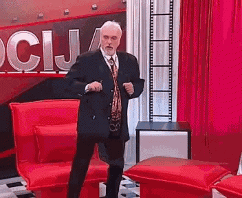 a man in a suit and tie is dancing in front of a sign that says ' ocija ' on it