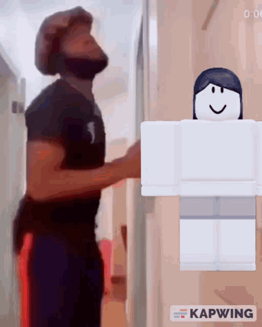 a man in a black shirt is standing next to a white roblox character that says kapwing
