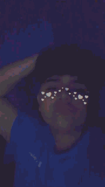 a person is making a peace sign with hearts on their face
