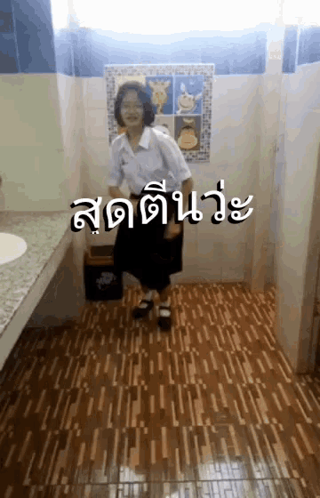 a girl in a white shirt and black skirt is standing in a bathroom with a sign on the wall that says ' a '