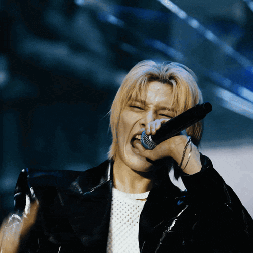 a man singing into a microphone with his mouth wide open