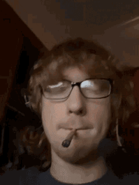 a man wearing glasses and headphones smoking a cigar