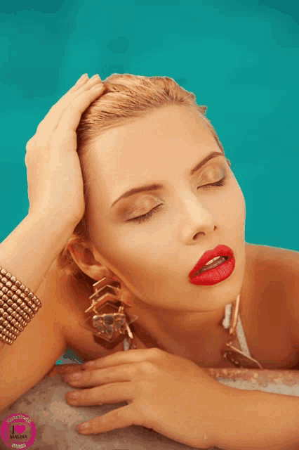 a woman wearing red lipstick and gold earrings is laying in a pool