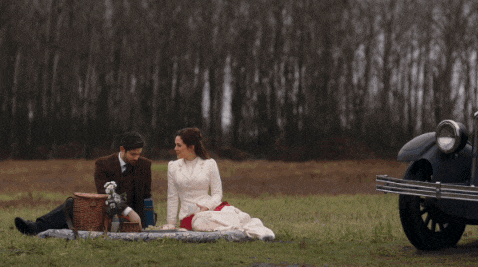 a man and a woman are having a picnic in the grass