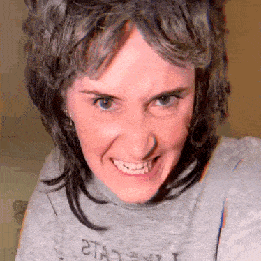 a close up of a woman 's face with a gray shirt that says 2ta on it