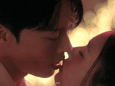 a close up of a man kissing a woman 's forehead with a blurred background that says anneji