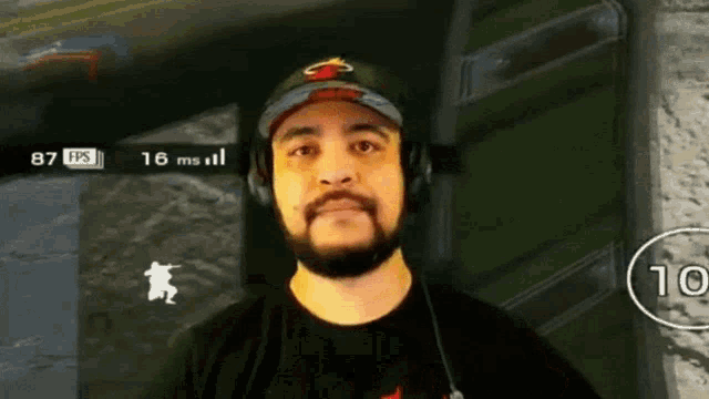 a man wearing headphones is playing a video game with a score of 87 fps