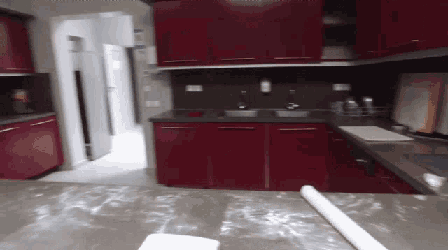 a kitchen with red cabinets and a rolling pin on the counter top