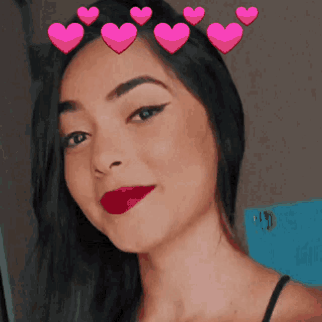 a woman with pink hearts on her head is smiling