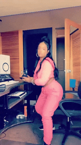 a woman in a pink outfit stands in front of a desk