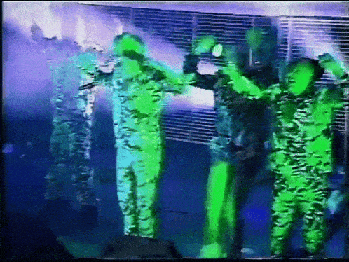a group of people are standing on a stage with their hands in the air