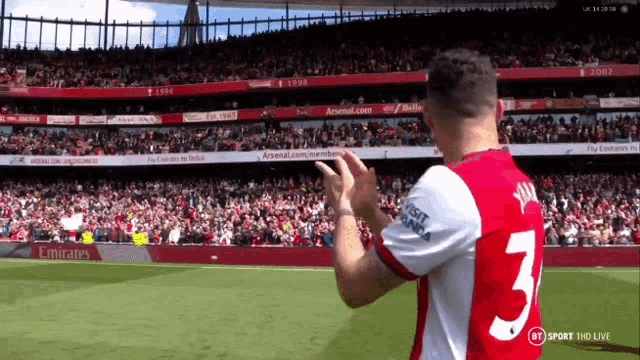 a soccer player with the number 3 on his jersey applauds the crowd