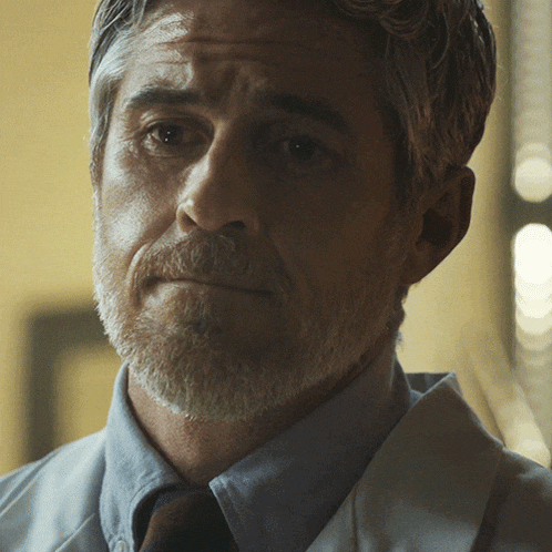 a man with a beard is wearing a white coat