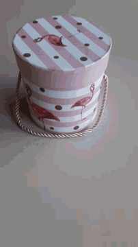 a pink and white striped box with flamingos and polka dots