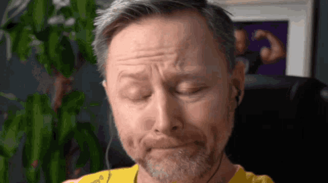 a man with a beard is wearing headphones and has his eyes closed .
